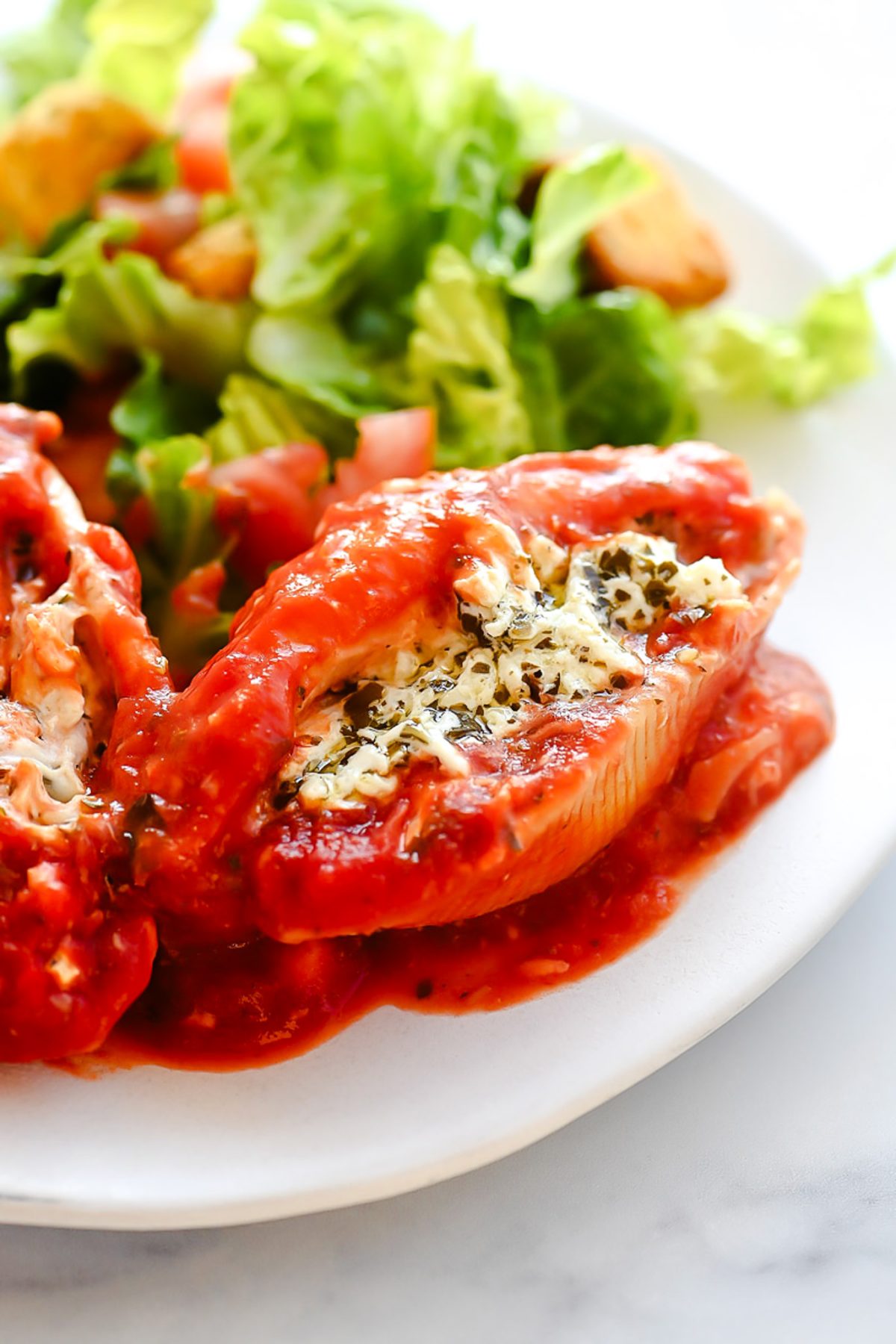 Chicken stuffed shells with pesto and cheese.