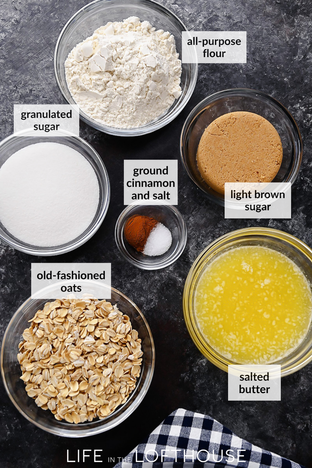 A warm berry crisp with bubbling mixed berries and a golden oat crumble topping, served in a white dish with a scoop of melting vanilla ice cream on top.