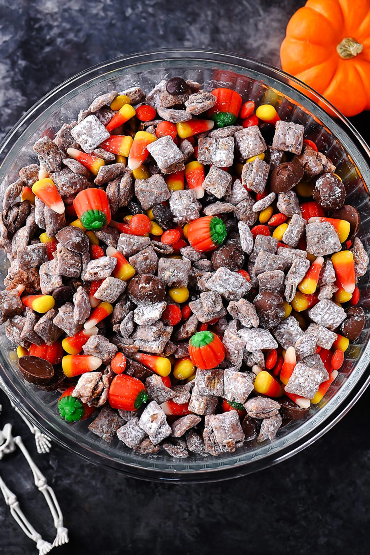 Halloween Muddy Buddies with rice Chex, chocolate, powdered sugar, and Halloween candy.