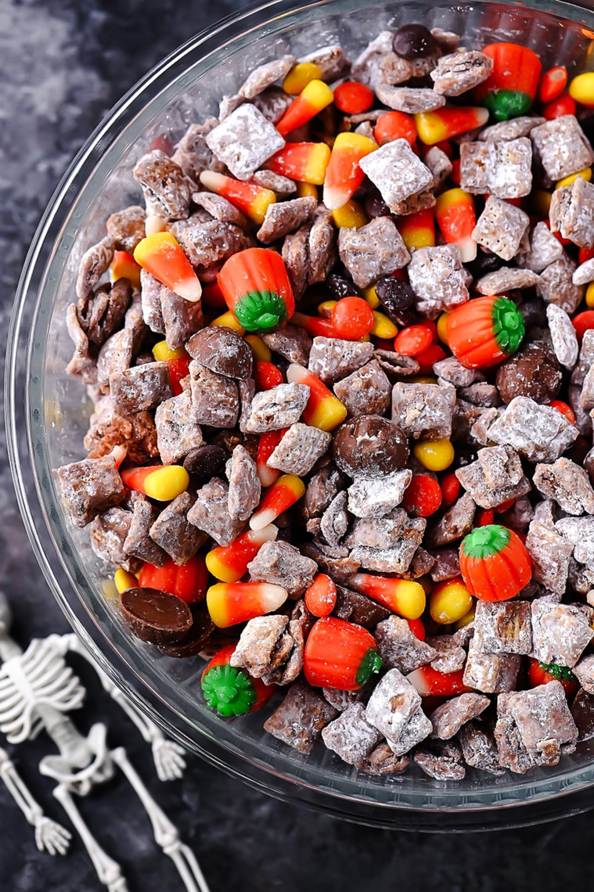 Halloween Muddy Buddies with rice Chex, chocolate, powdered sugar, and Halloween candy.