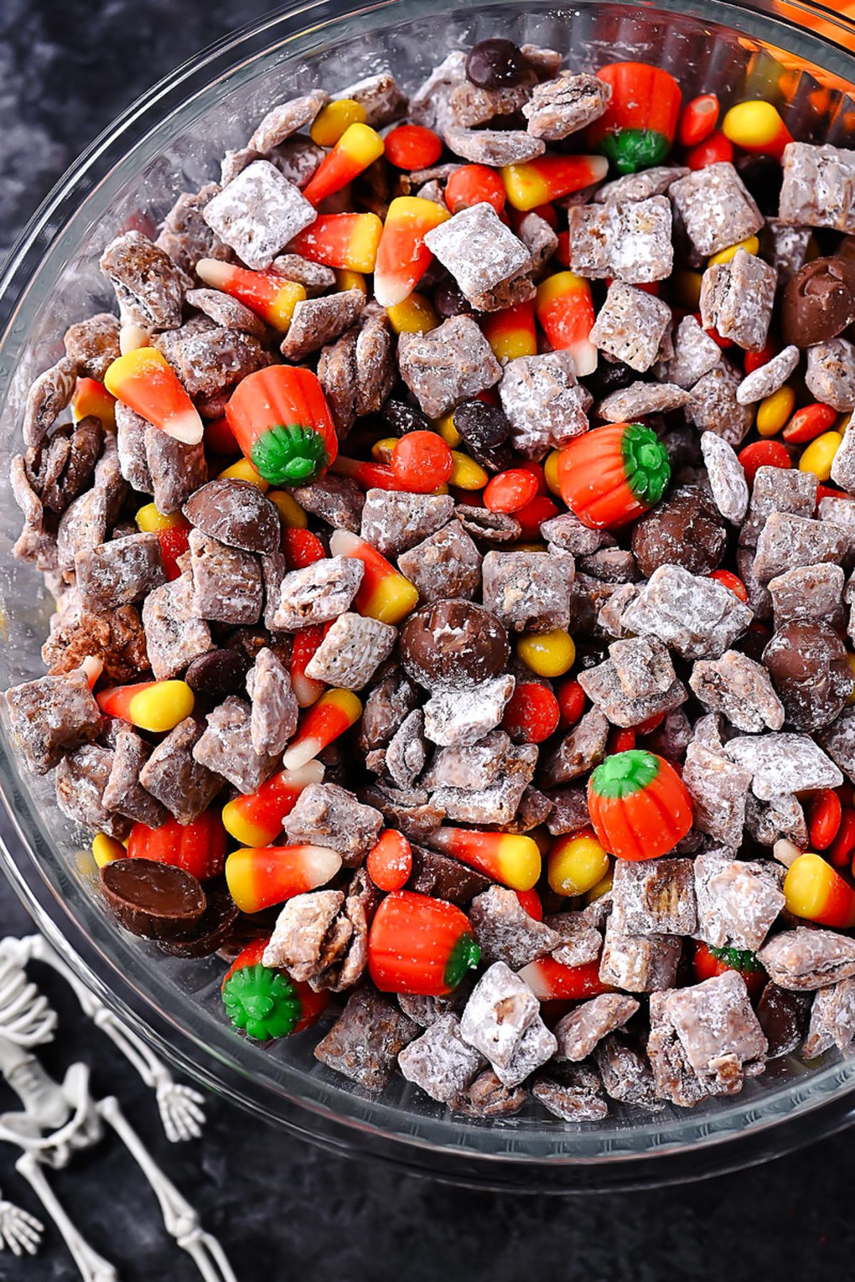 Halloween Muddy Buddies with rice Chex, chocolate, powdered sugar, and Halloween candy.