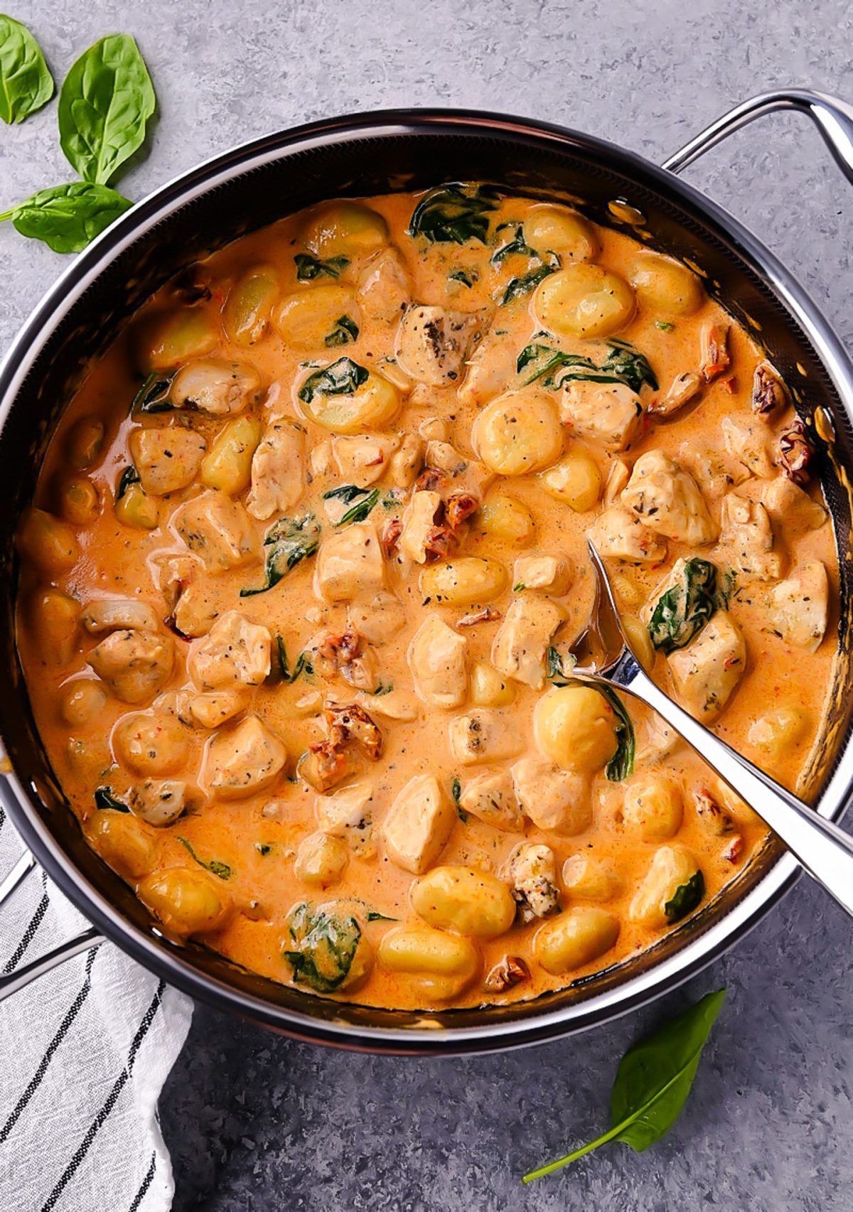 Creamy Chicken and Gnocchi, featuring tender chicken, sun-dried tomatoes, spinach, and a rich Parmesan cream sauce.