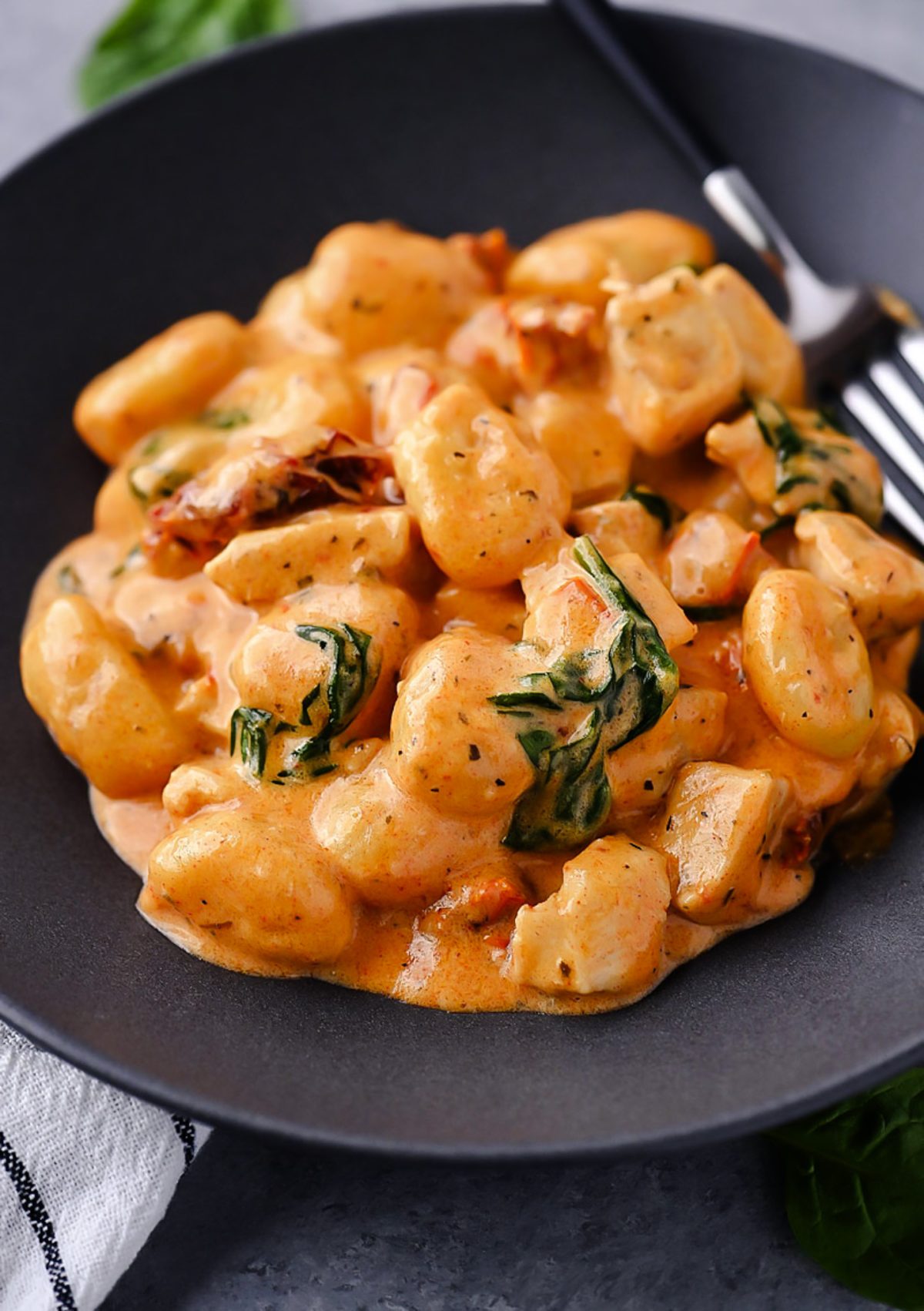 Creamy Chicken and Gnocchi, featuring tender chicken, sun-dried tomatoes, spinach, and a rich Parmesan cream sauce.