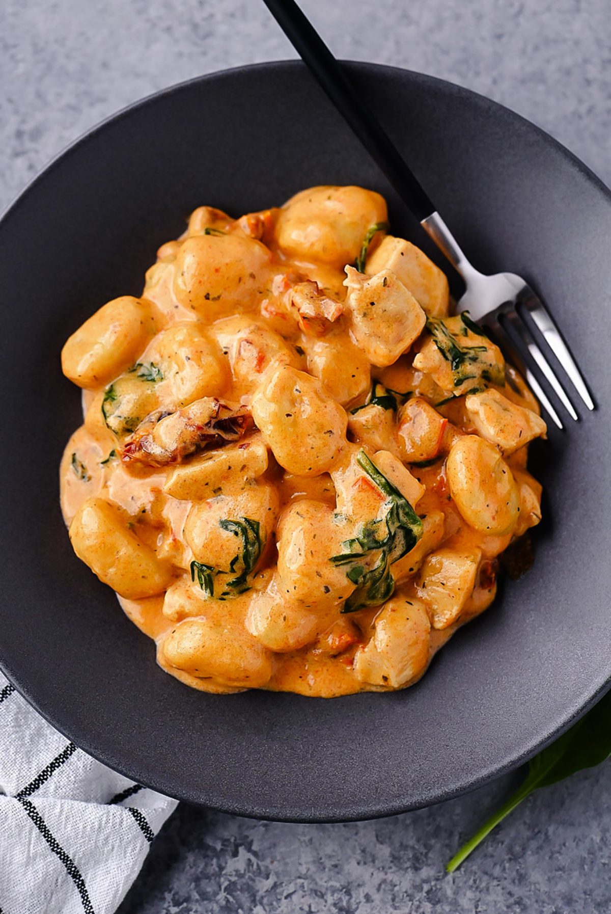 Creamy Chicken and Gnocchi, featuring tender chicken, sun-dried tomatoes, spinach, and a rich Parmesan cream sauce.